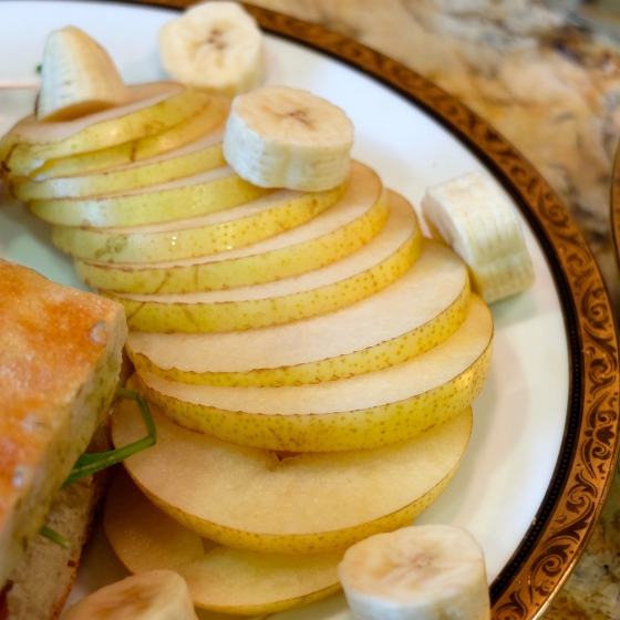 Cored and sliced fresh yellow asian pear chips and banana. 